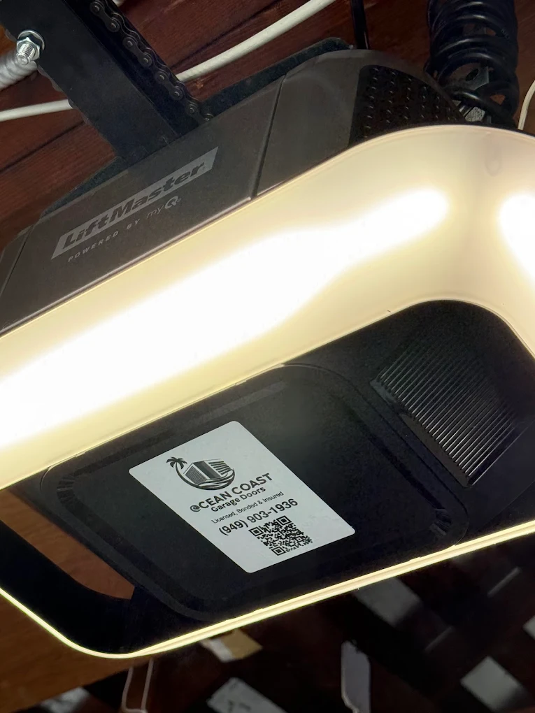 An illuminated modern LiftMaster garage door opener with a service provider sticker attached, helping homeowners evaluate LiftMaster garage door opener repair vs replacement.